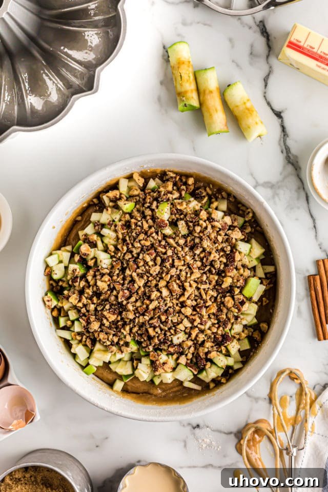 apples and nuts added to apple spice cake batter