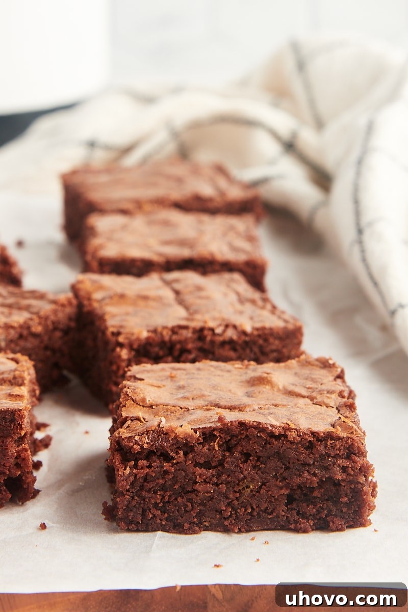 Fudgy brownies neatly lined up on parchment paper, ready to be served or stored.