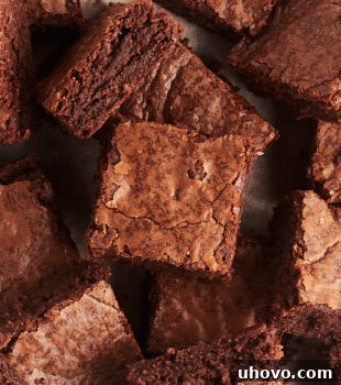 Overhead view of a pile of fudgy brownies, showcasing their rich texture.