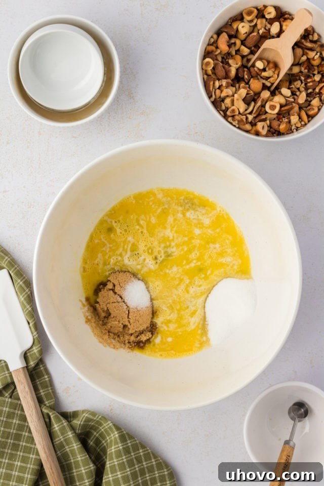 Overhead view of sugars and salt added to beaten eggs in bowl