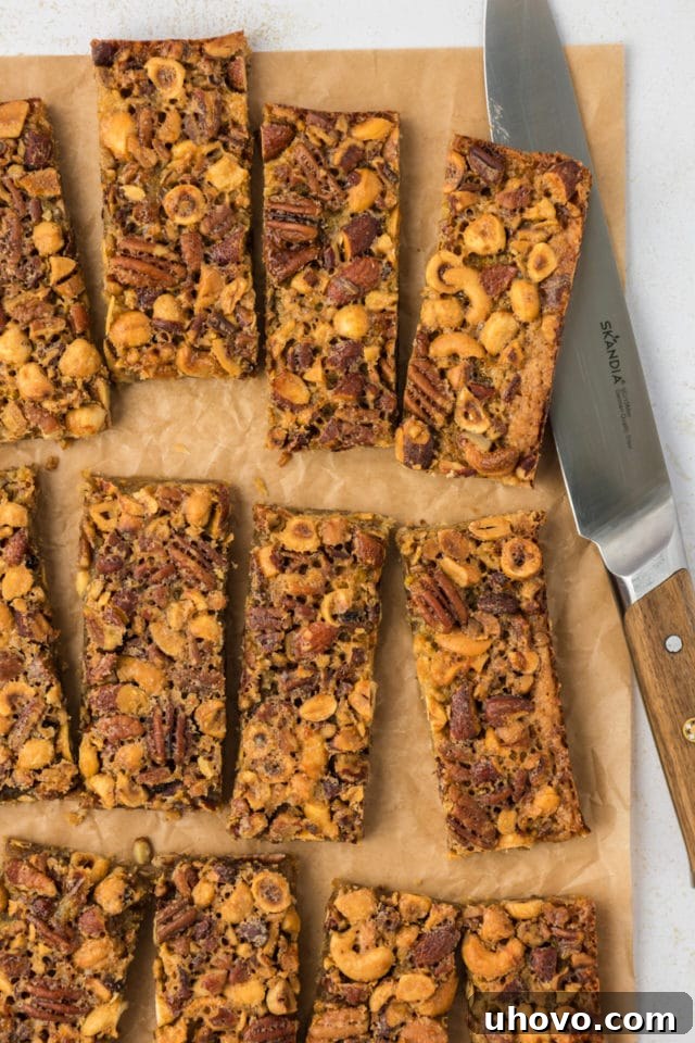 Overhead view of cut maple nut bars on parchment paper with knife