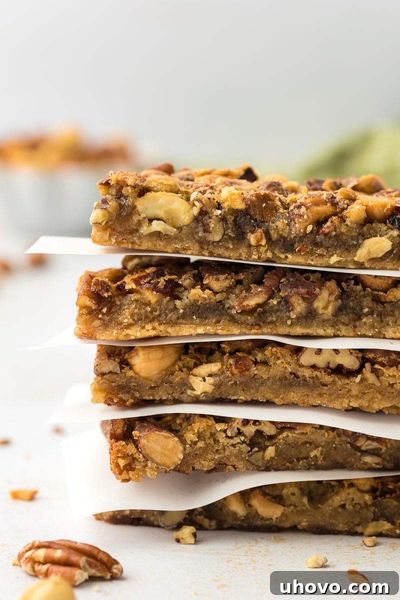 Stack of maple nut bars with parchment paper between layers