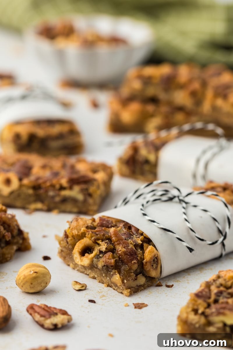 Maple nut bar wrapped in parchment and tied with bakers twine, with additional bars in background