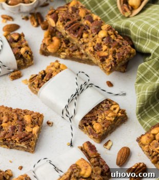 Maple nut bars on countertop, with some wrapped in parchment and tied with bakers twine