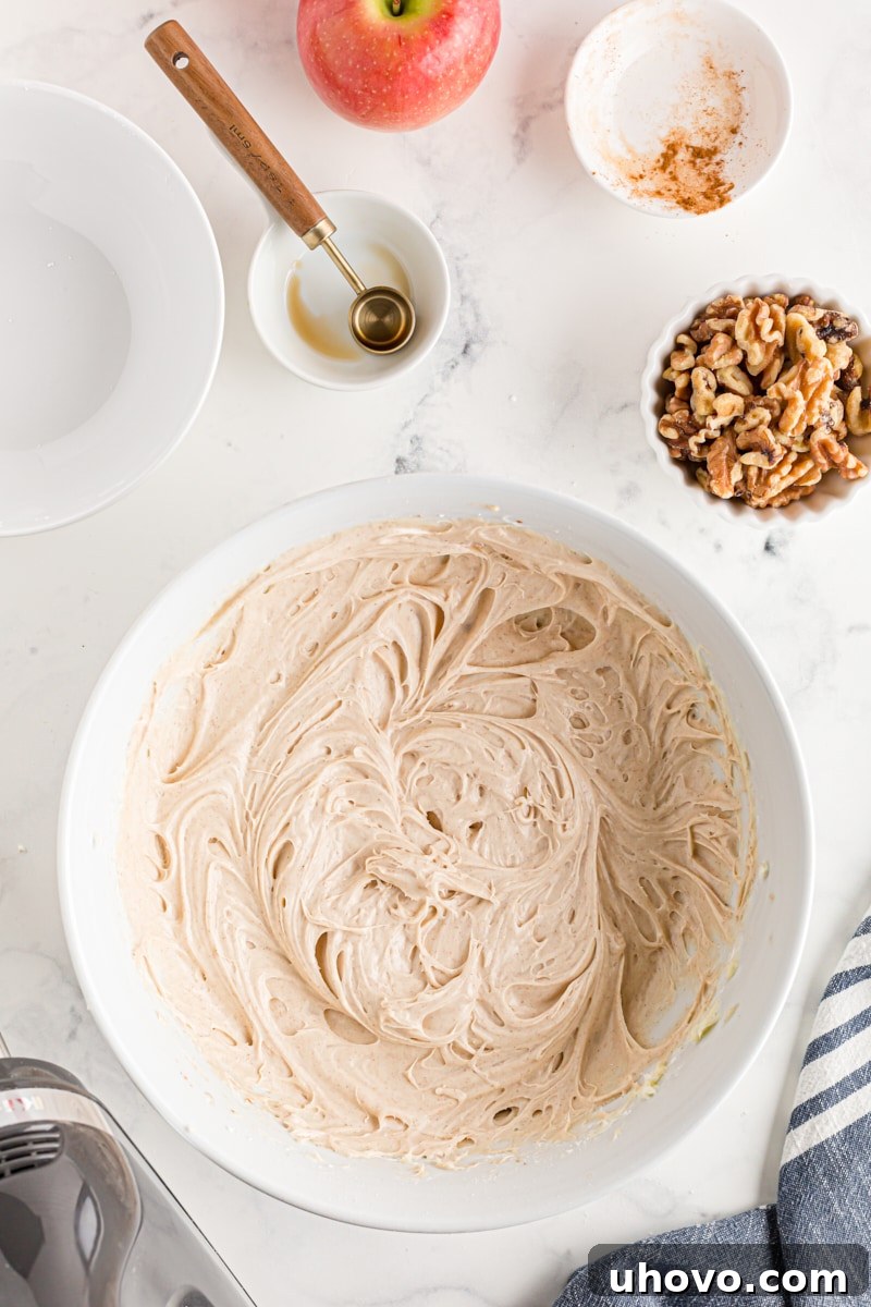 Overhead view of the finished cinnamon cream cheese frosting in a white mixing bowl, perfectly smooth and ready to use