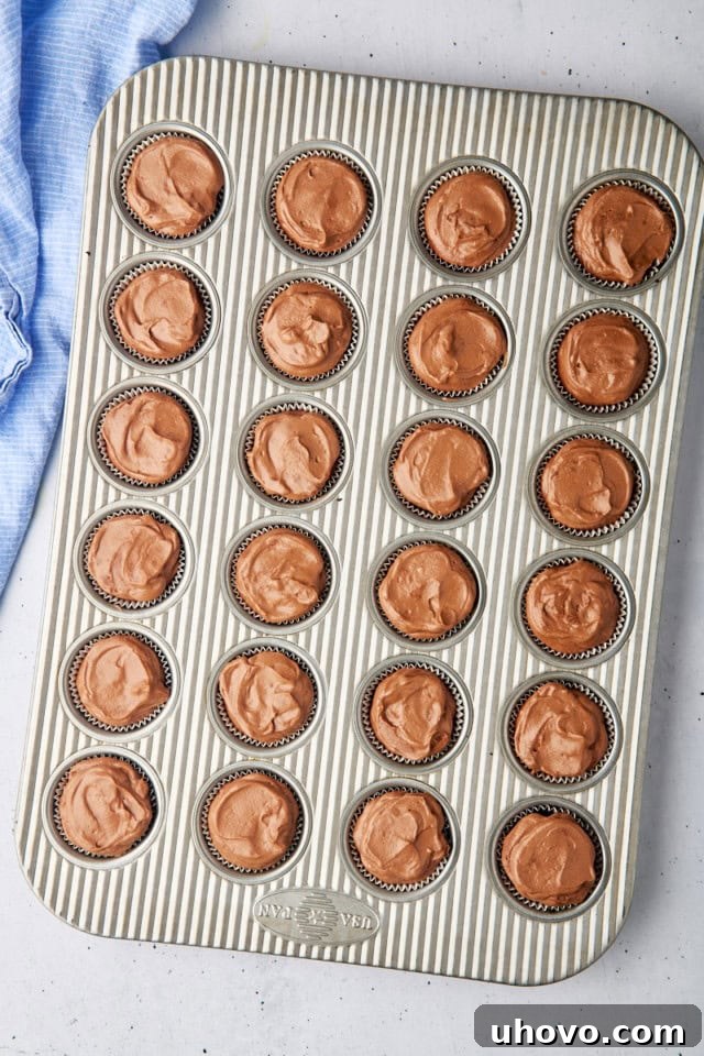 Overhead view of the mini no-bake chocolate cheesecakes nestled in their mini muffin pan, perfectly assembled and ready to be chilled to set before serving.