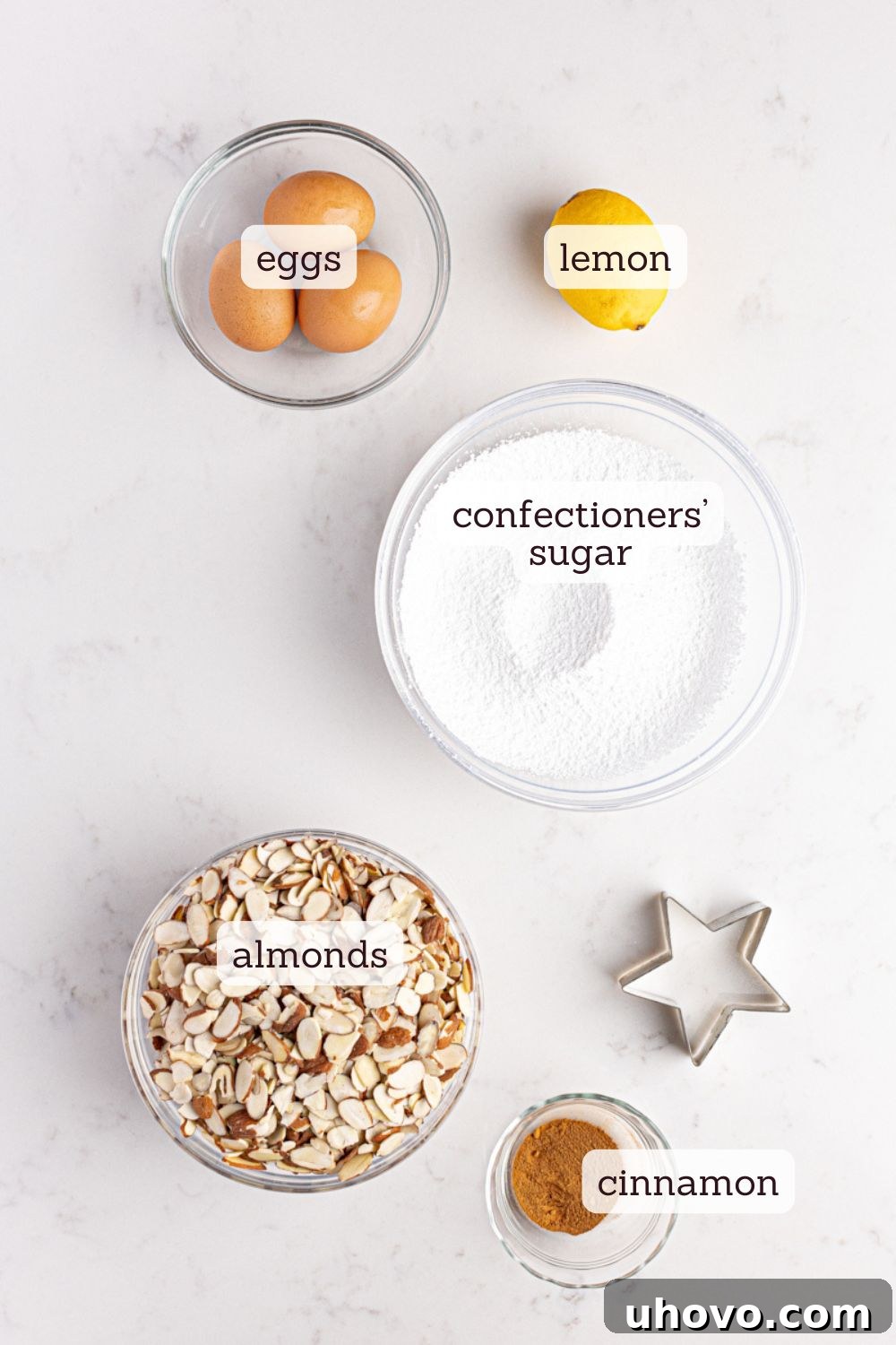Overhead view of ingredients for Zimtsterne cinnamon stars, neatly laid out on a surface