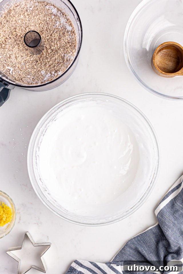 Whipped egg whites in a mixing bowl, forming soft peaks