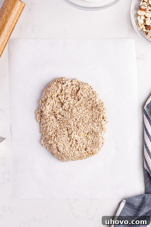 Overhead view of Zimtsterne dough on parchment paper, ready for rolling
