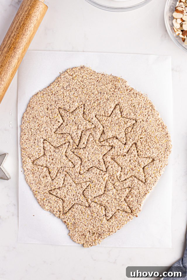 Overhead view of Zimtsterne dough cut into precise star shapes