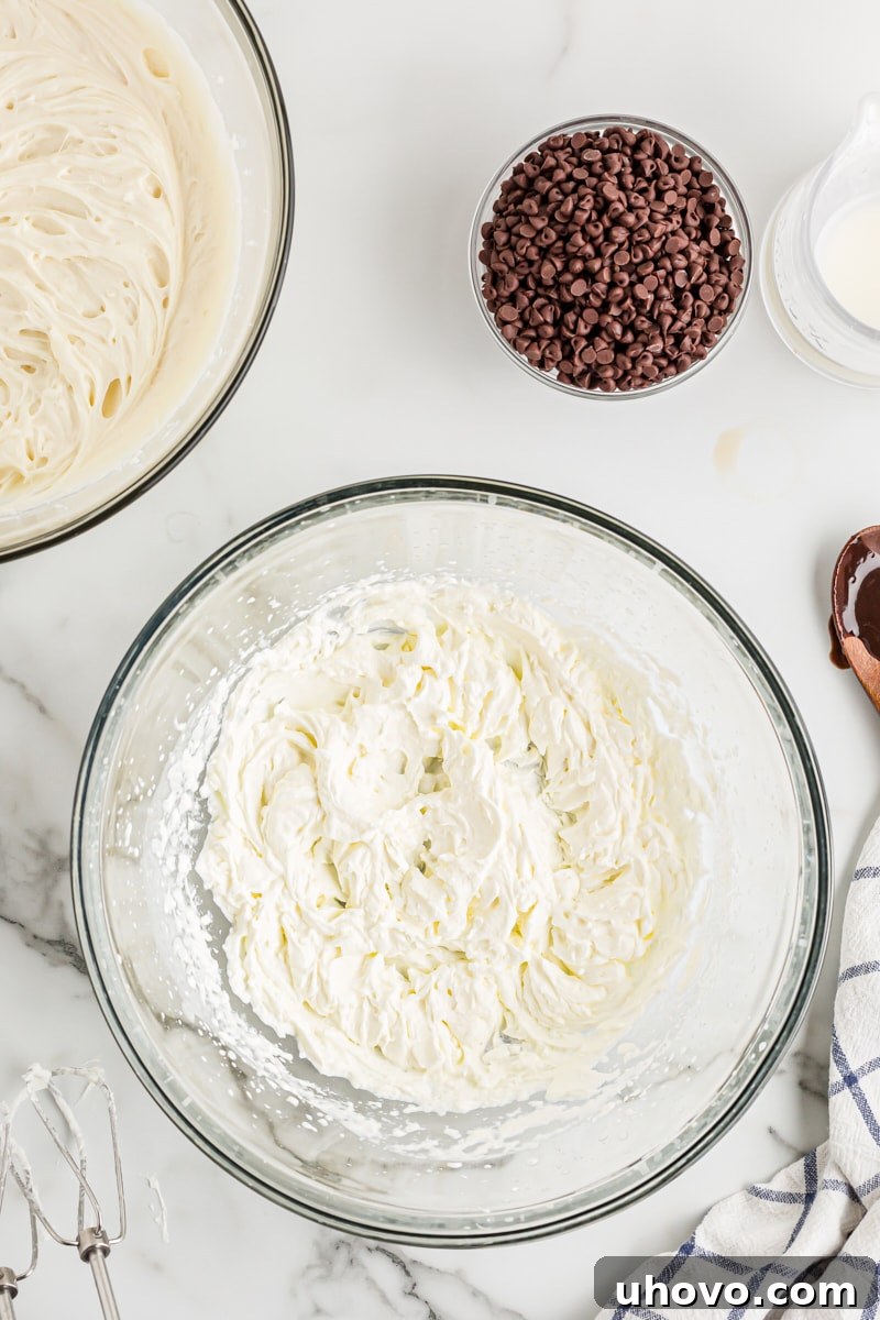 An overhead view of freshly whipped cream in a mixing bowl, showcasing its light and airy texture.