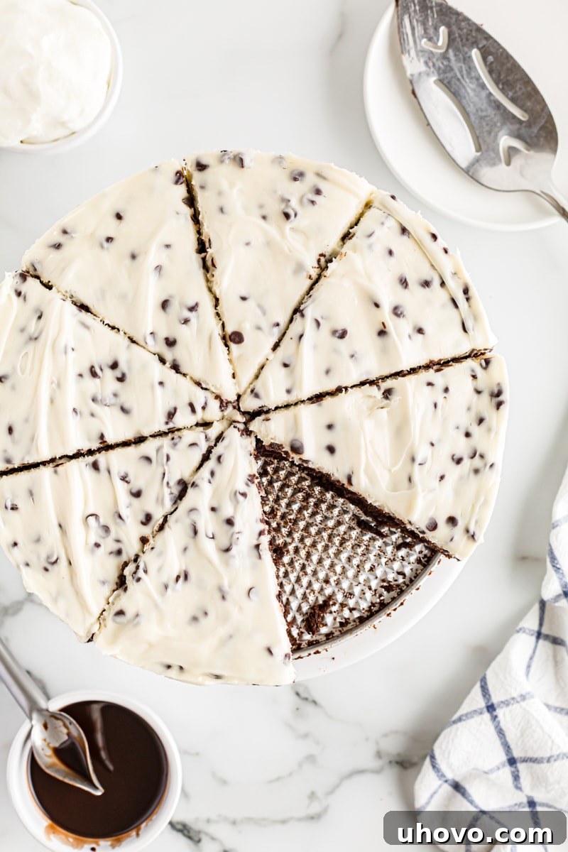 An artistic overhead view of a whole Chocolate Chip Cheesecake with Brownie Crust, already pre-sliced into inviting wedges, showcasing its perfect layers and readiness to serve.