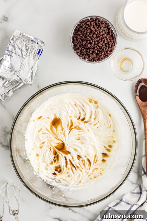 A stream of vanilla extract being poured into a bowl of creamy cheesecake batter, adding an essential aromatic touch.