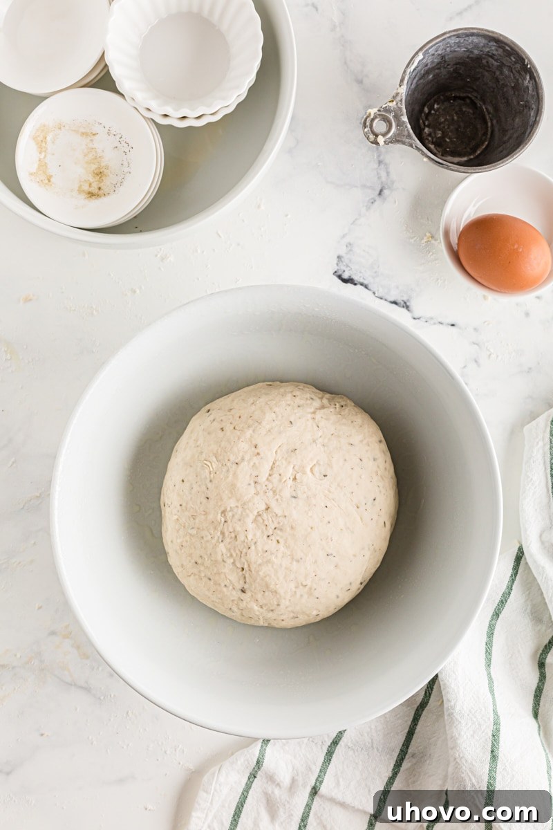 A perfectly formed ball of dough nestled in a bowl, ready for its first rise.
