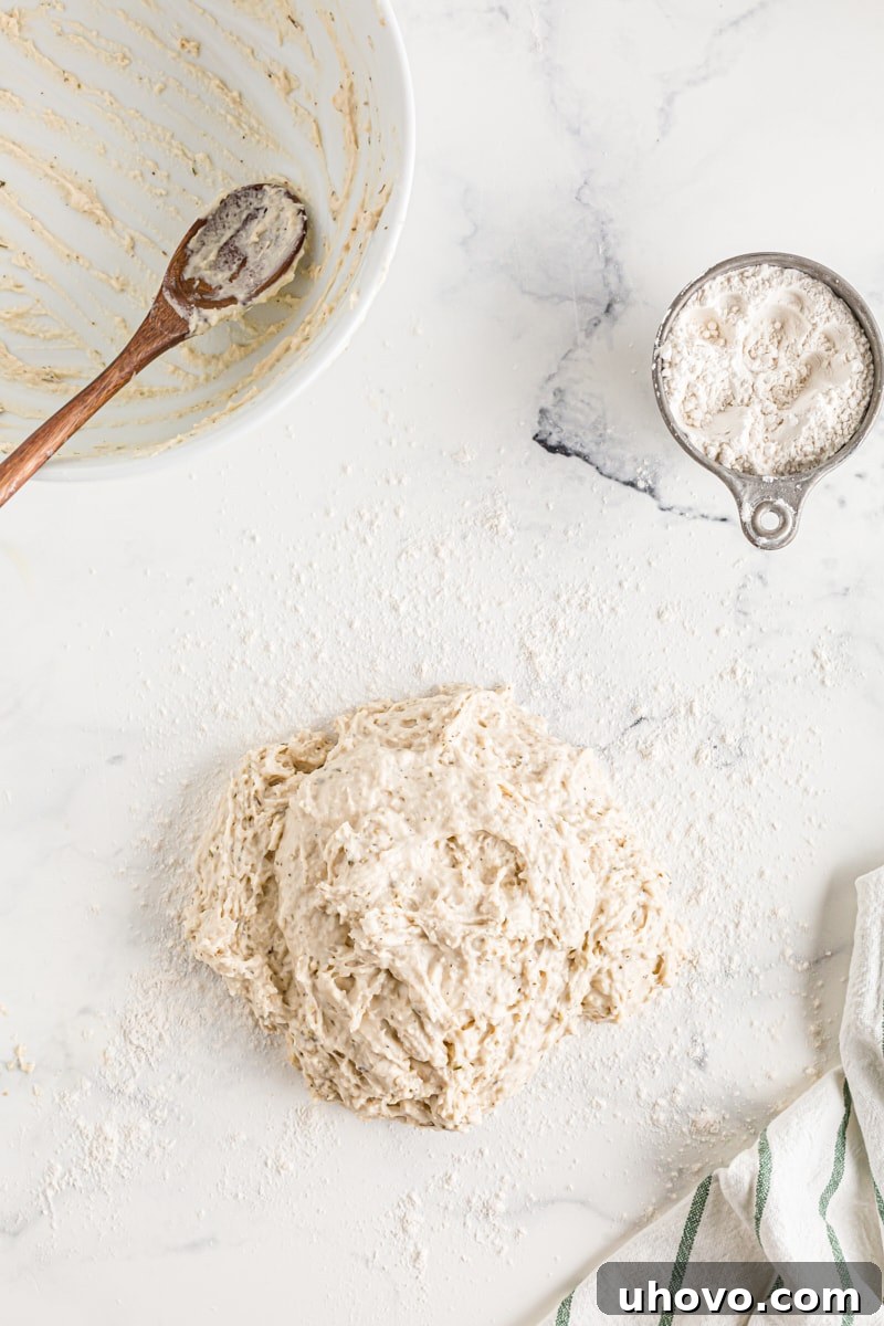 Soft bread roll dough in a mixing bowl, before the final amount of flour is incorporated.