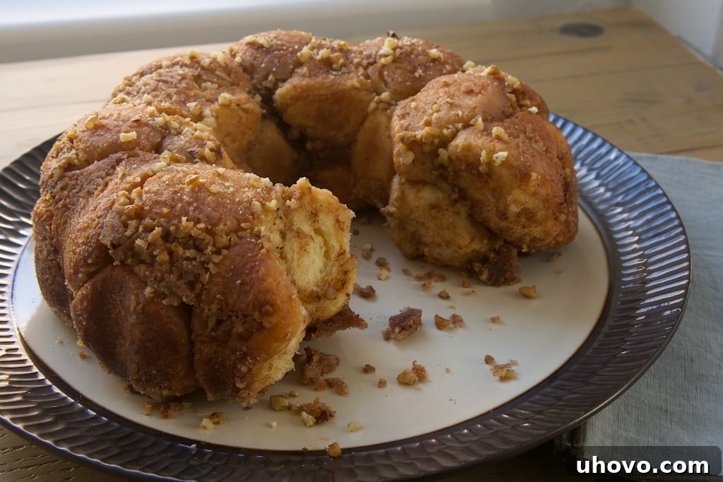 Brown Butter Cinnamon Pecan Pull Apart Bread on serving platter, with pieces removed