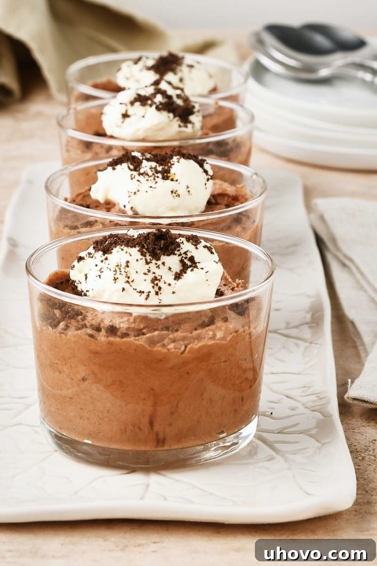 Decadent Easy Chocolate Mousse in a glass cup with whipped cream.