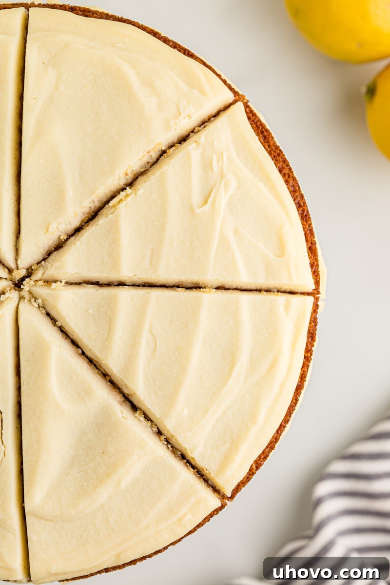 Overhead view of a whole lemon cream cake expertly cut into several inviting slices, ready to be served.