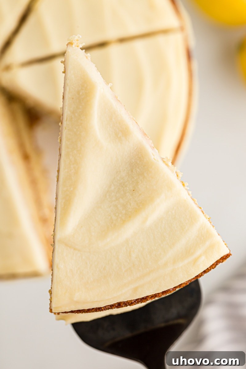 Overhead view of a perfect slice of lemon cream cake being lifted off the plate with a serving spatula, ready to be enjoyed.