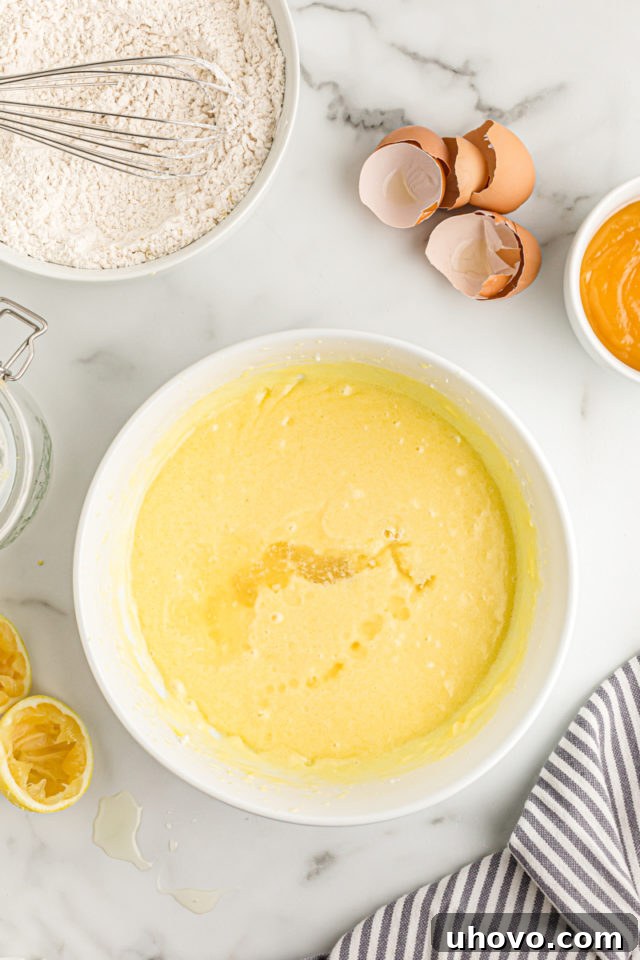 Overhead view of the fully combined wet ingredients for the lemon cream cake, a smooth and creamy mixture in a large mixing bowl.