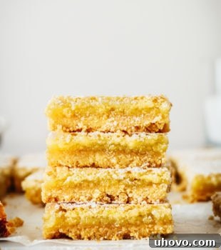 Stack of 4 lemon bars on parchment paper