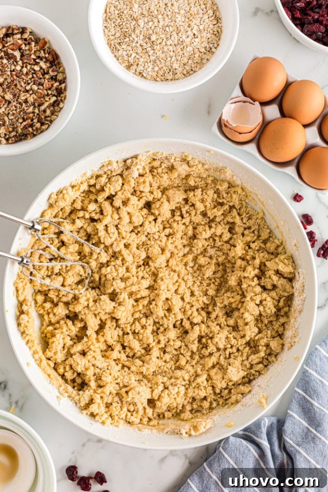 A top-down shot of cookie dough in a white mixing bowl, perfectly mixed with a few visible streaks of flour remaining, indicating the ideal stage before adding mix-ins for tender cookies.
