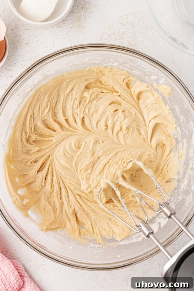 Overhead view of the fully mixed berry swirl pound cake batter in a glass mixing bowl, ready for swirling.