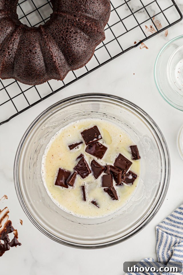 Overhead view of chocolate pieces in bowl with glaze ingredients