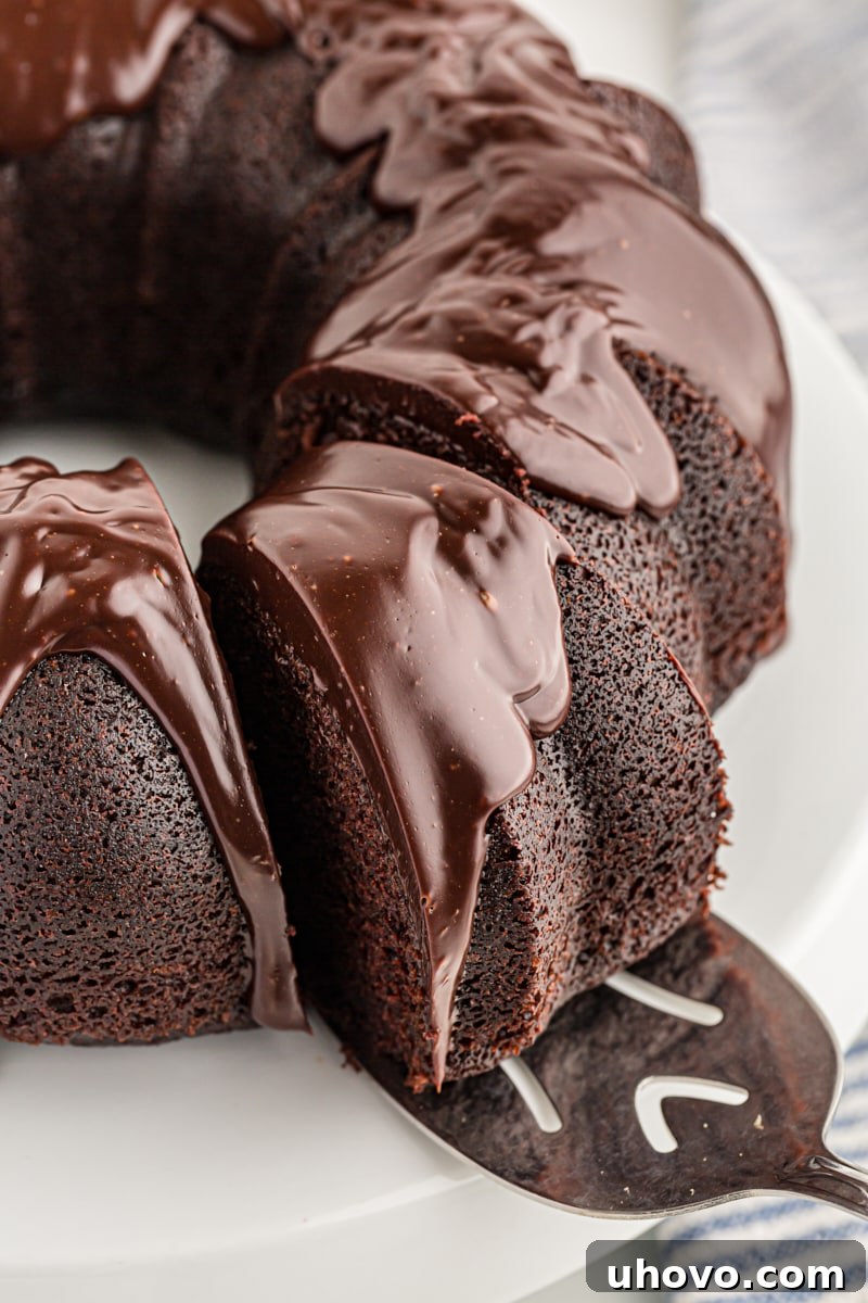 Removing a slice of chocolate sour cream Bundt cake from cake stand