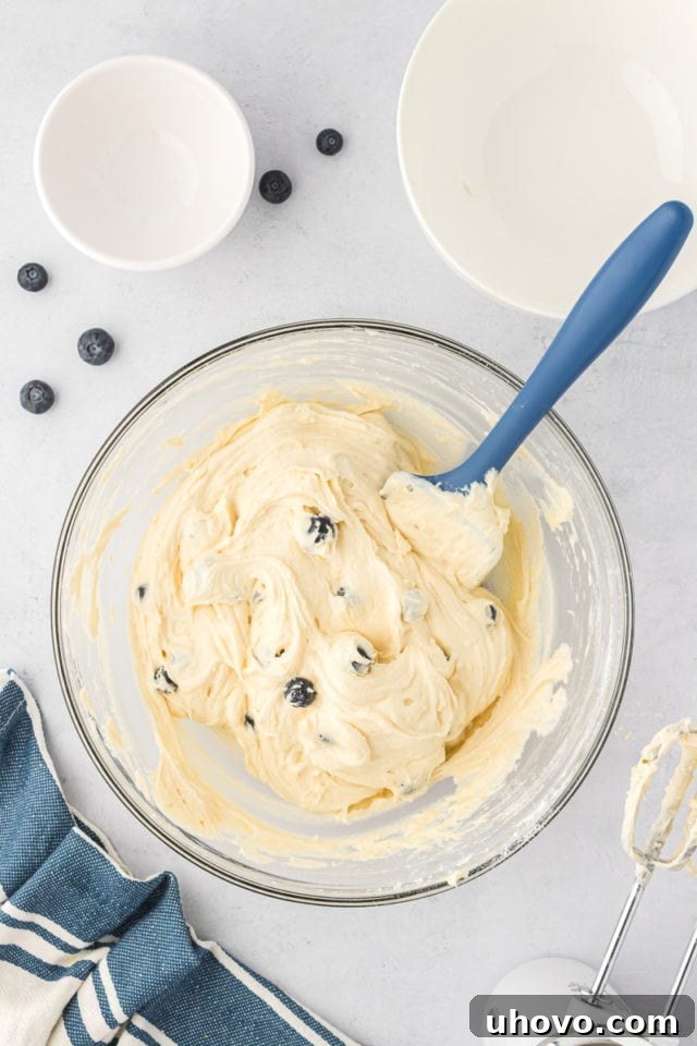 overhead view of mixed lemon blueberry cookie dough in a glass mixing bowl