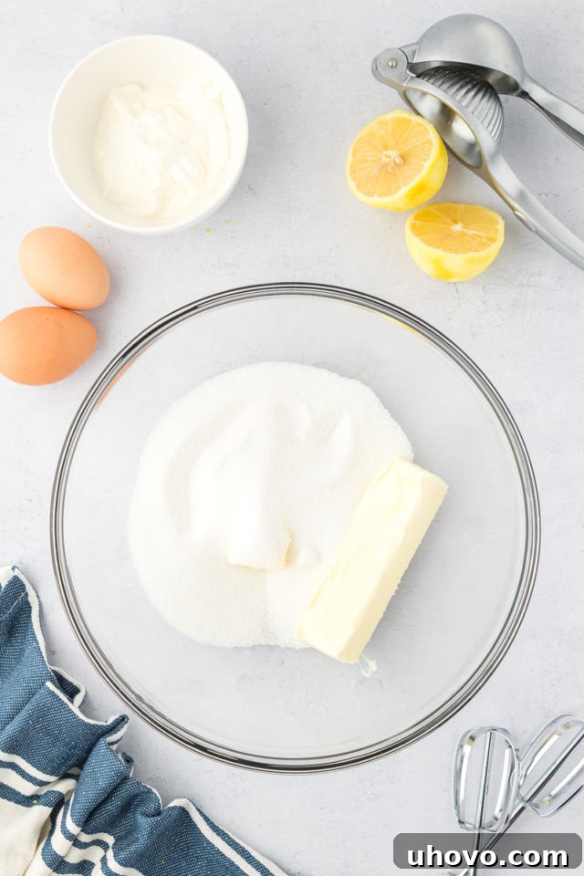 overhead view of sugar and butter in a glass mixing bowl