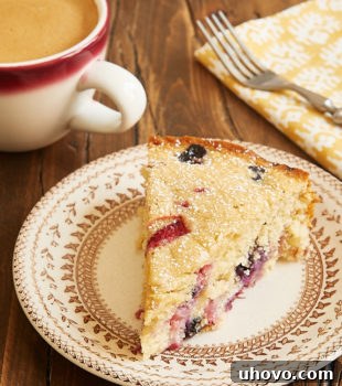 A beautiful slice of Berry Muffin Cake on a floral-rimmed beige plate.