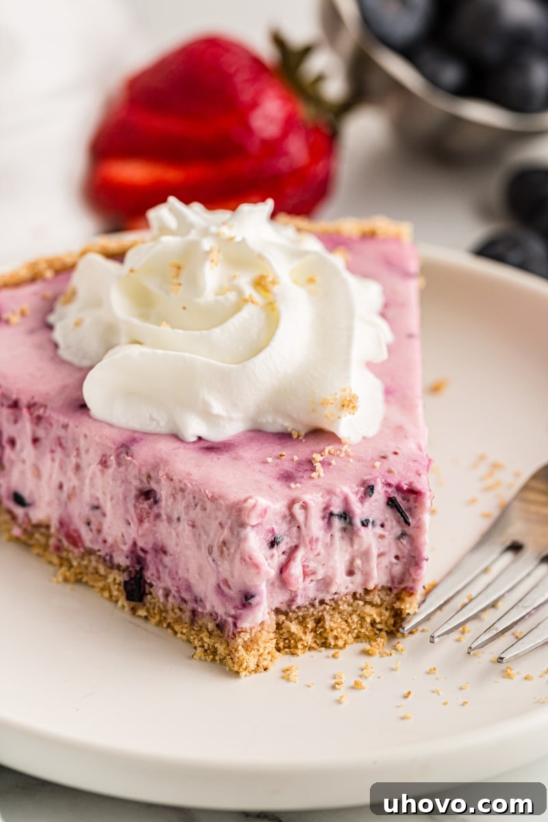 Slice of berry cheesecake on a plate with a bite taken out, showing the creamy texture