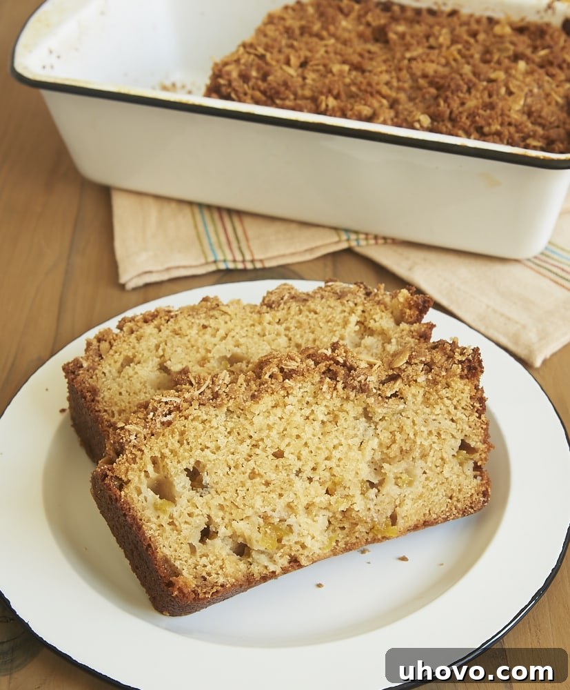 Close-up of a rustic loaf of Peach Streusel Bread, showcasing the golden-brown streusel topping and visible chunks of sweet peaches