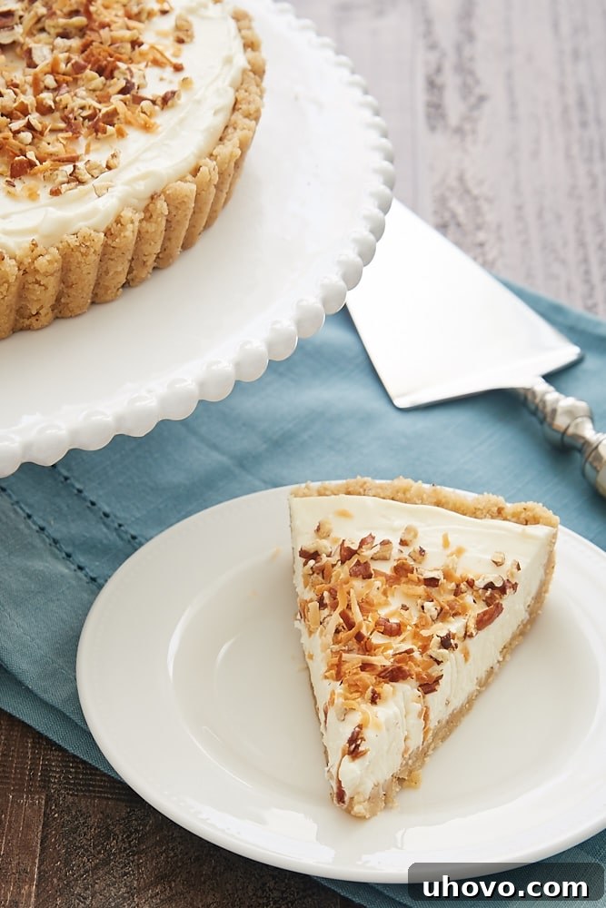 A beautiful Italian Cream Tart, garnished with toasted pecans and coconut, presented whole on a white serving plate, ready to be enjoyed.
