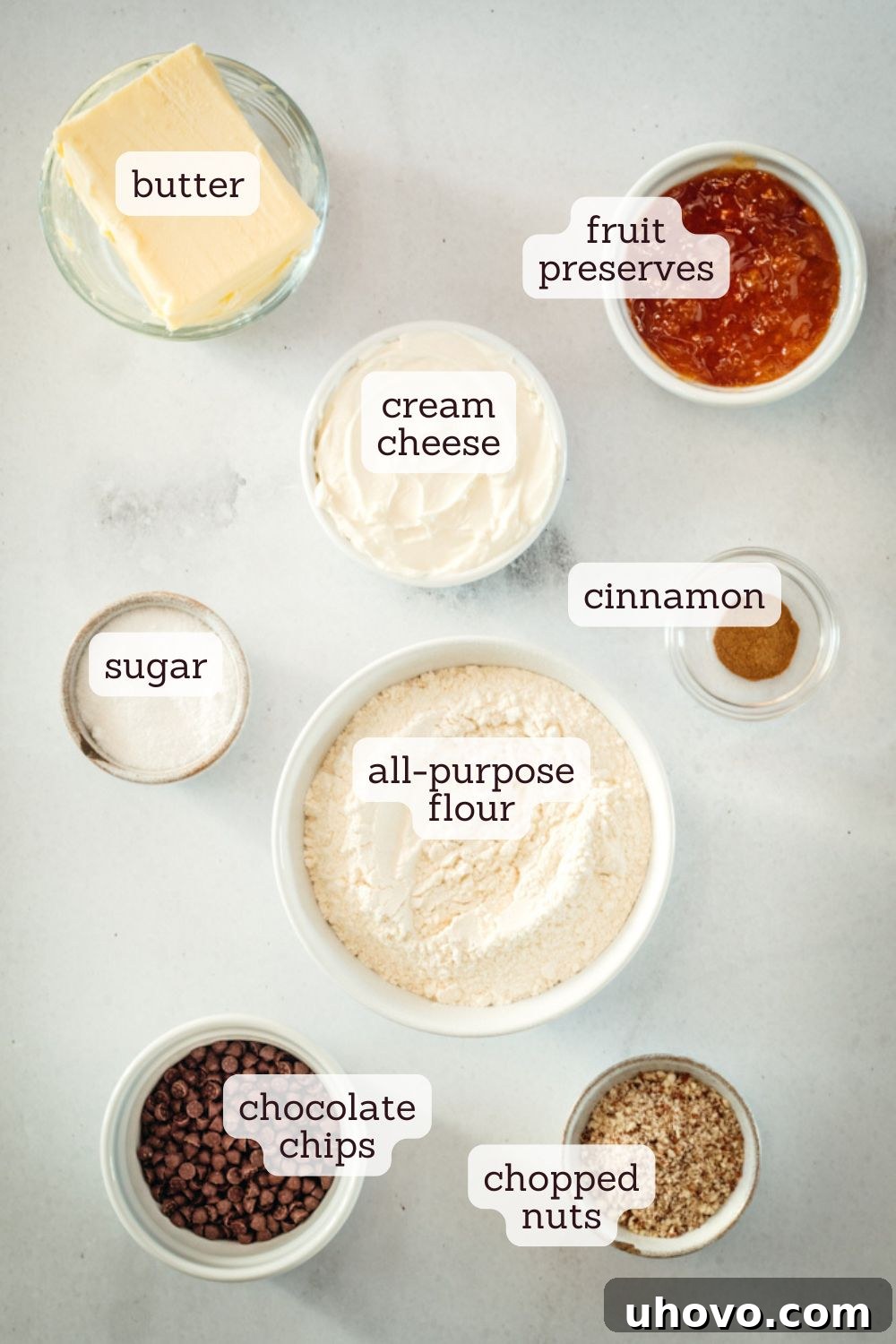 overhead view of ingredients for rugelach: butter, cream cheese, flour, sugar, cinnamon, preserves, chocolate chips, pecans