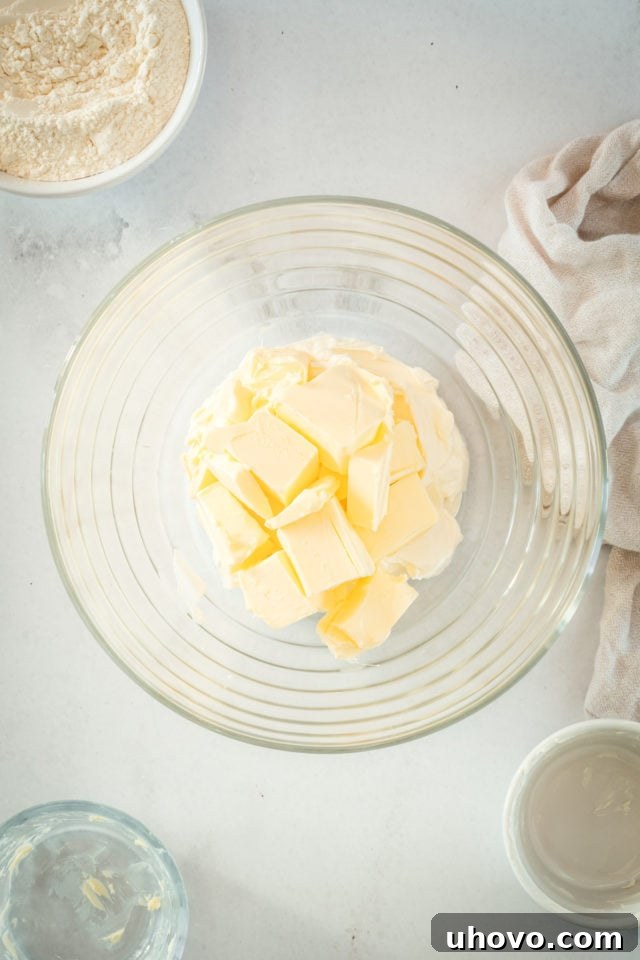Overhead view of butter and cream cheese in glass mixing bowl
