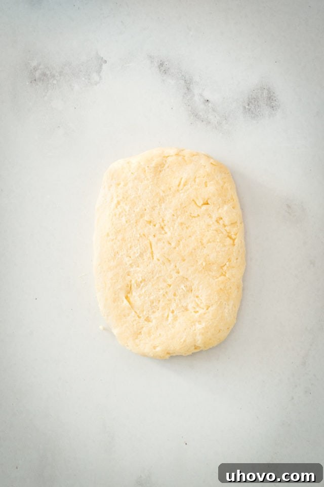 Overhead view of rectangle of dough on marble slab