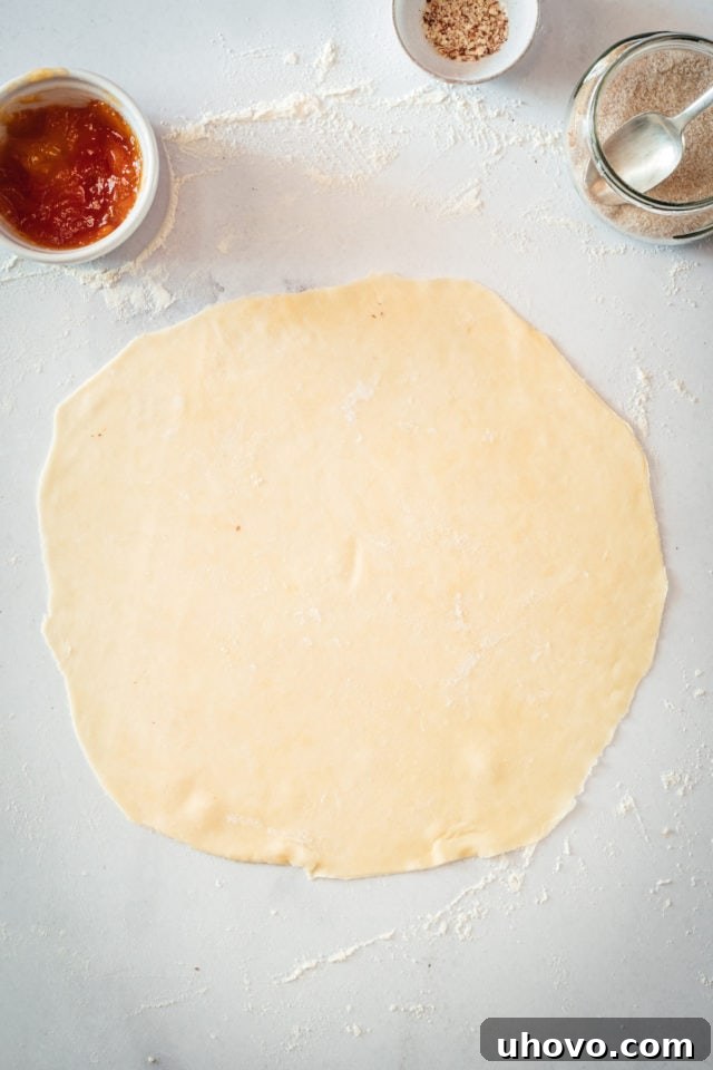 Circle of dough rolled out on marble surface
