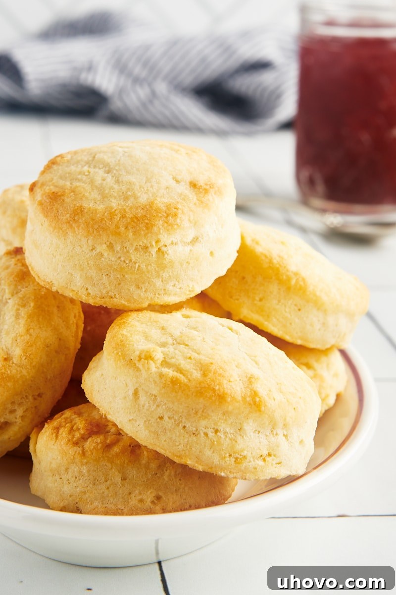 Stack of golden brown cream biscuits in a rustic bowl, showcasing their inviting texture.