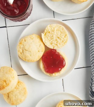 Overhead view of cream biscuits on plates with jam