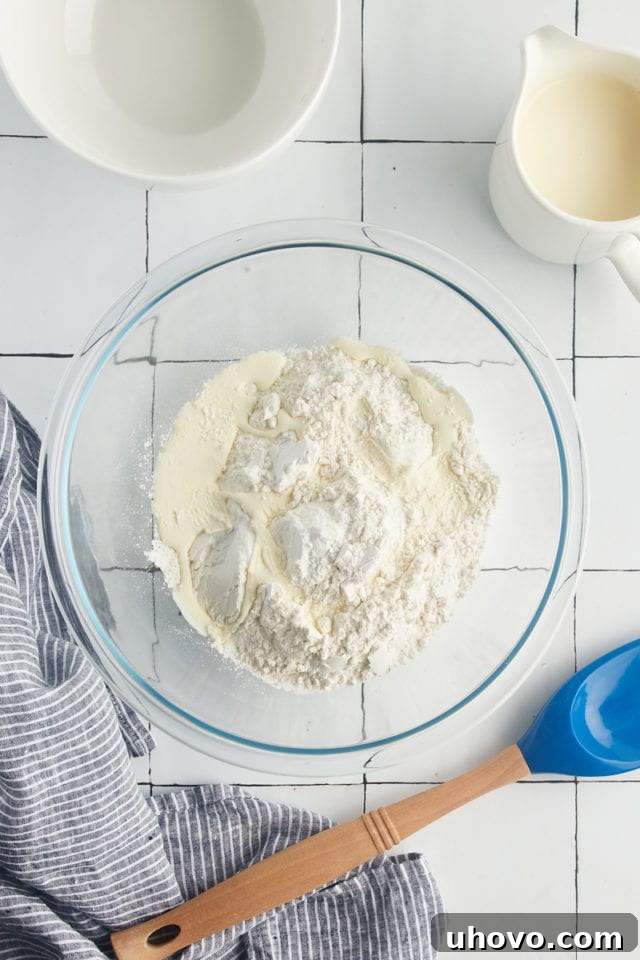 Overhead view of dry self-rising flour in a clear mixing bowl, ready for cream.
