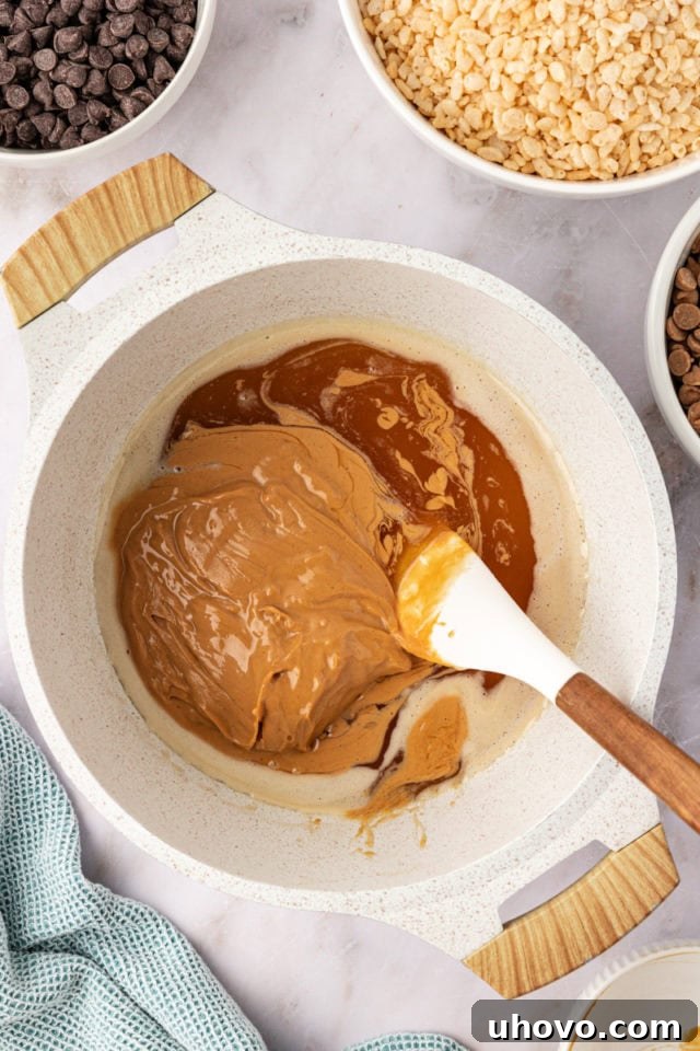 Peanut butter being added to the warm honey and sugar mixture in a saucepan, to be stirred until a smooth, rich base forms.