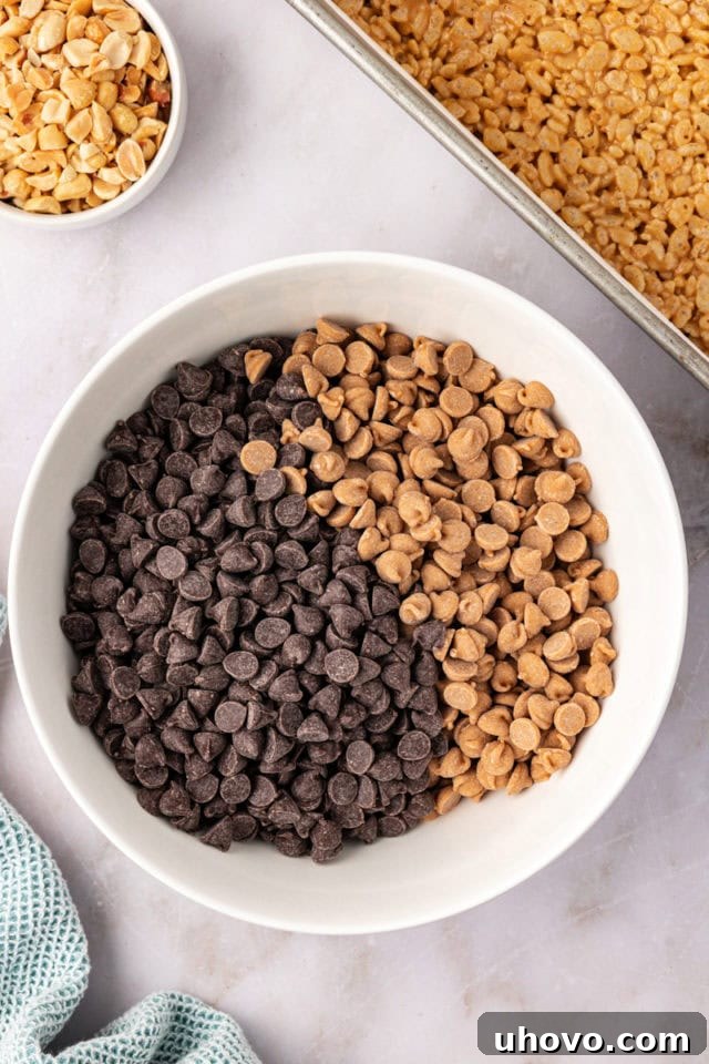 A white bowl brimming with a colorful mix of chocolate chips and peanut butter chips, awaiting melting to create the rich, smooth topping.