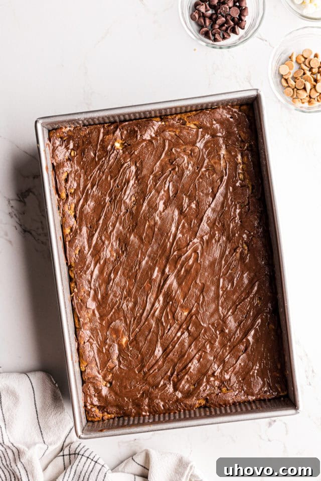 Overhead view of peanut butter mud bars in pan before adding chocolate and peanut butter chips on top