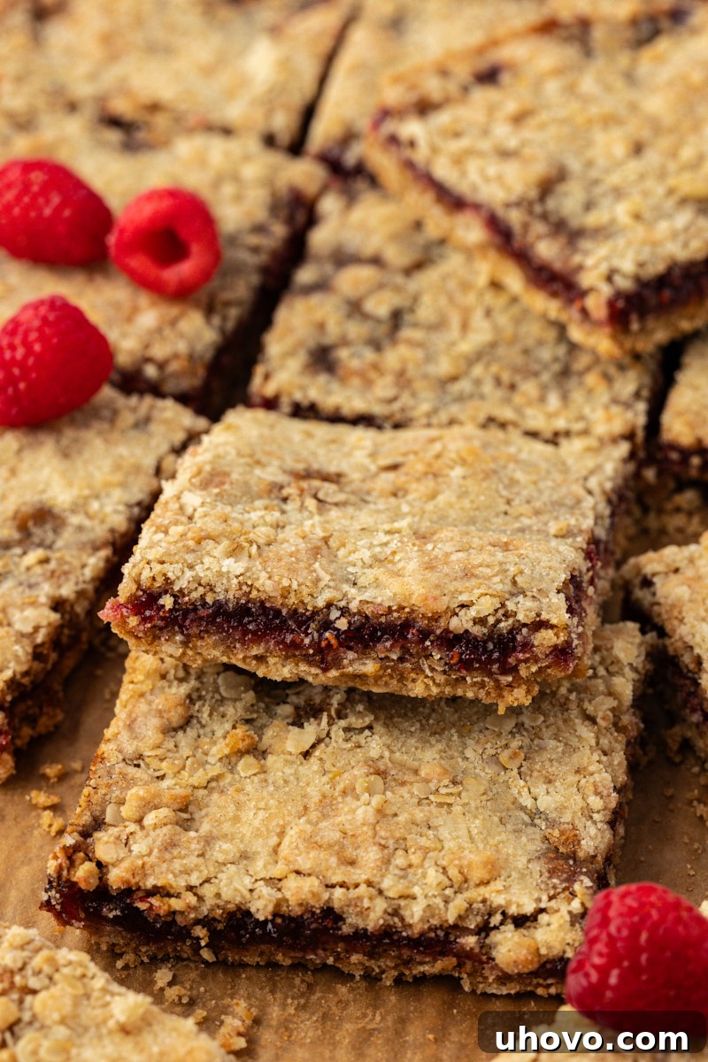 raspberry oatmeal bars layered on a wooden cutting board