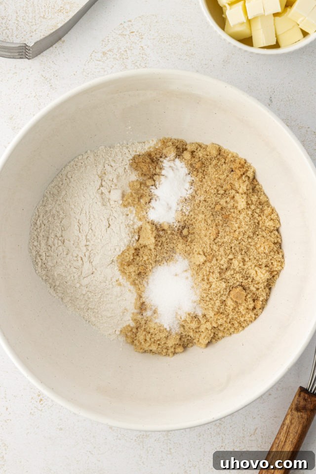 overhead view of brown sugar, flour, baking soda, and salt in a mixing bowl