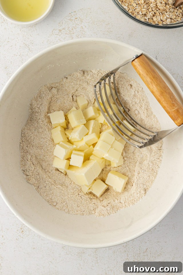overhead view of butter added to dry ingredients for raspberry oatmeal bars