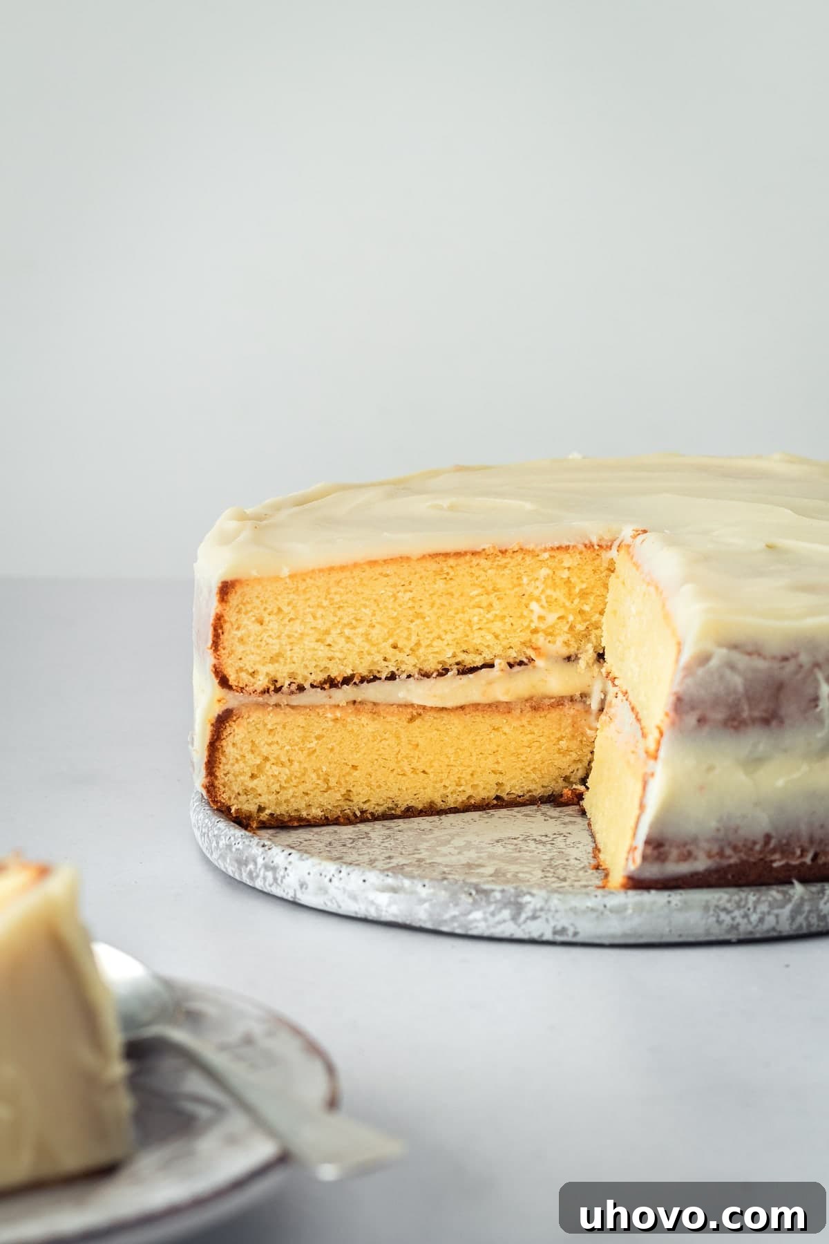 A beautifully sliced caramel cake with caramel cream cheese frosting, several slices removed from the center, showcasing its inviting layers and readiness for serving at a festive gathering.