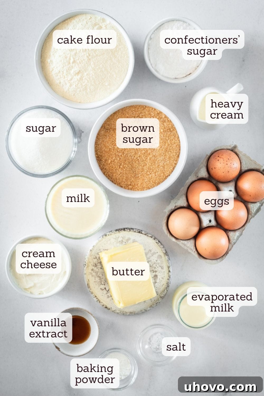 An overhead view of labeled ingredients for a caramel cake, neatly arranged on a kitchen counter, highlighting the fresh, high-quality components used in this delicious recipe.
